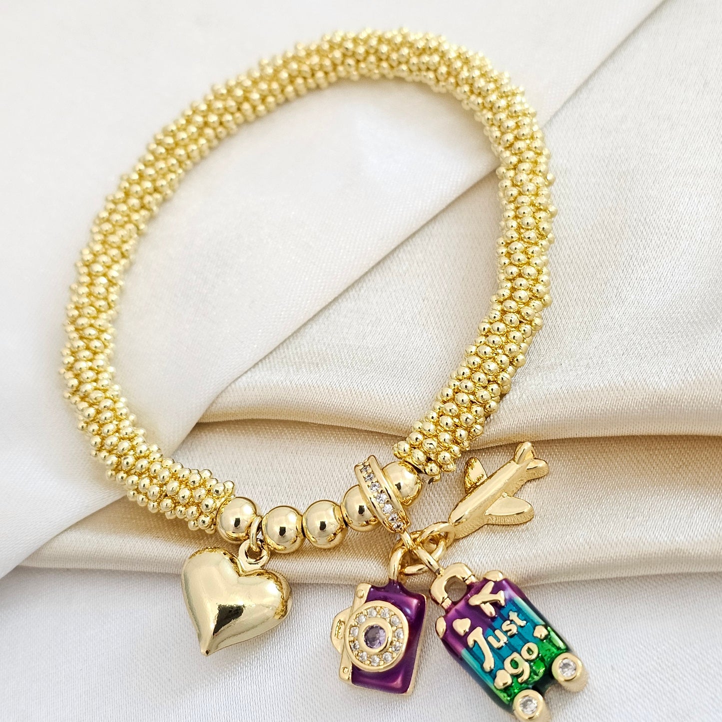 PULSERA FLEXIBLE FLORES DORADO CON CHARMS VIAJE MORADO RF K4872