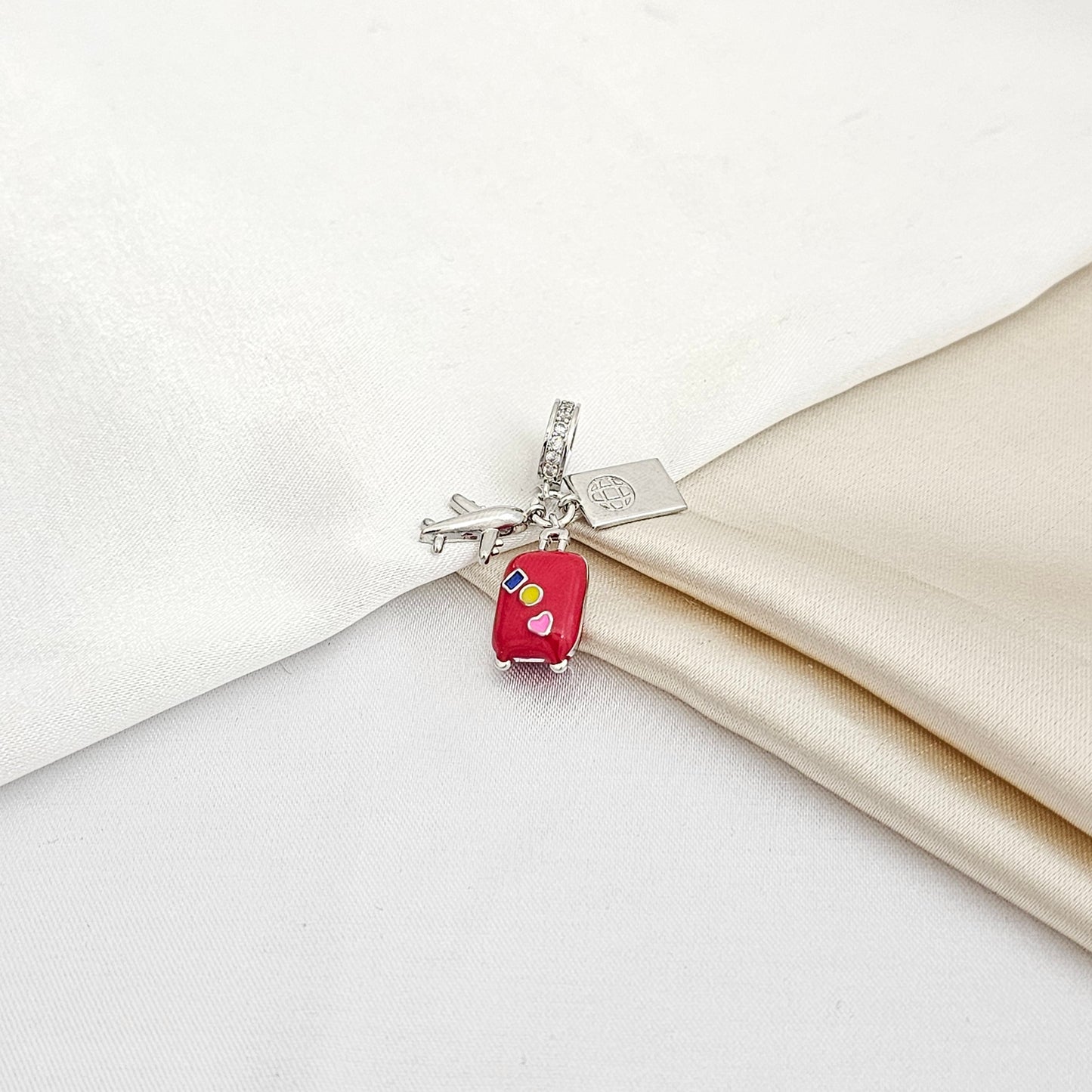 CHARM AVION PLATEADO Y MALETA ROJA RF K5236